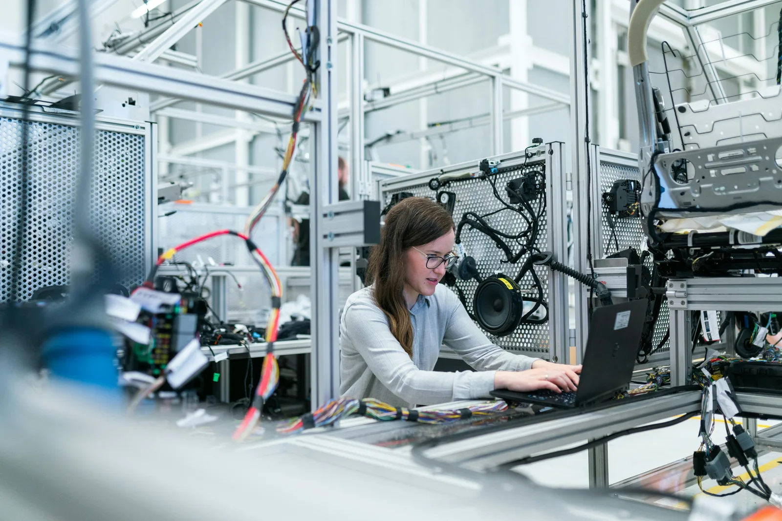 Person working at a computer beside industrial machinery