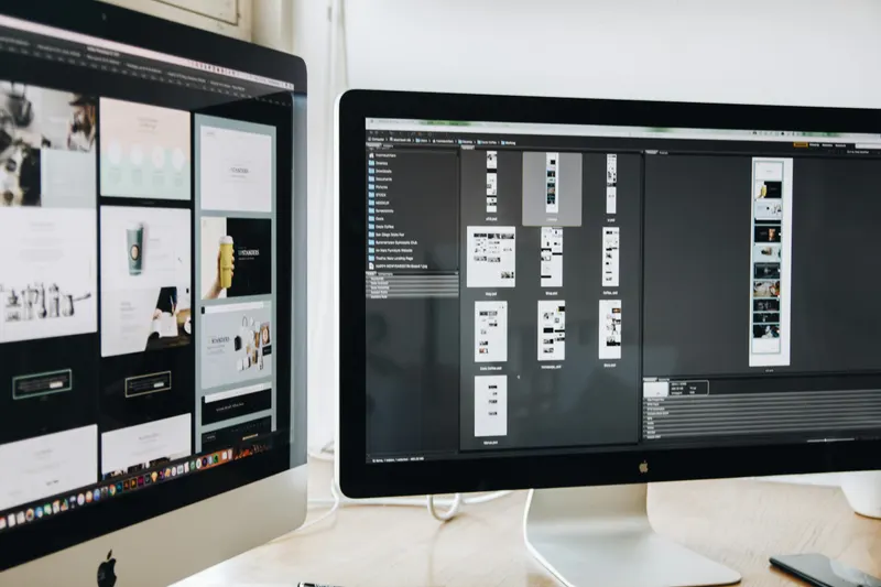 Two monitors displaying web design software